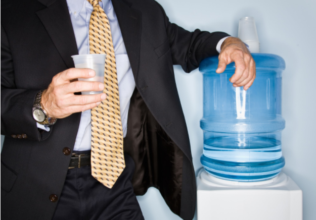 Man in suit standing near water cooler