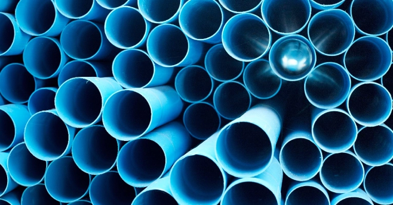 A stack of blue PVC pipes used for water line replacement in Edmonton, AB.