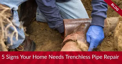 A plumber's hand inspecting a clogged pipe, with the words '5 signs your home needs trenchless pipe repair' at the bottom.