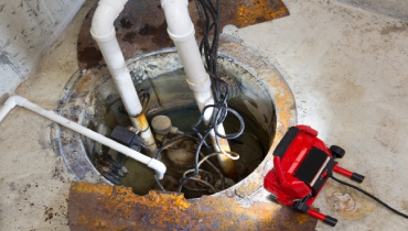 Close-up of a sump pump being repaired in the basement of a residential home.