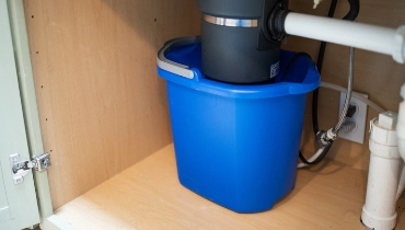 Bucket placed underneath a sink.