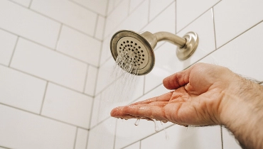 Hand under running shower water