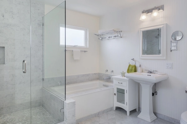 A modern, marble tile bathroom with an open walk-in shower and bathtub