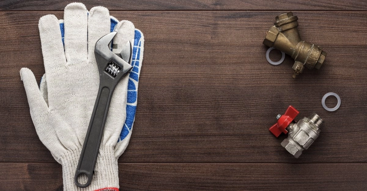 Glove and wrench used by a plumber for gas line installation in Edmonton.