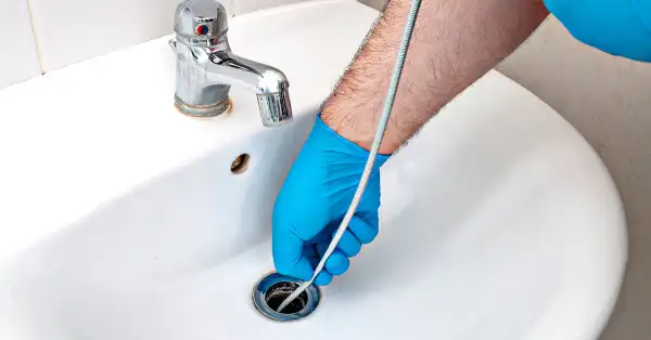 Calgary plumber uses drain snake to clean sewer line