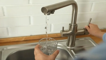 Performing a water test with a test tube held by a man in blue gloves.