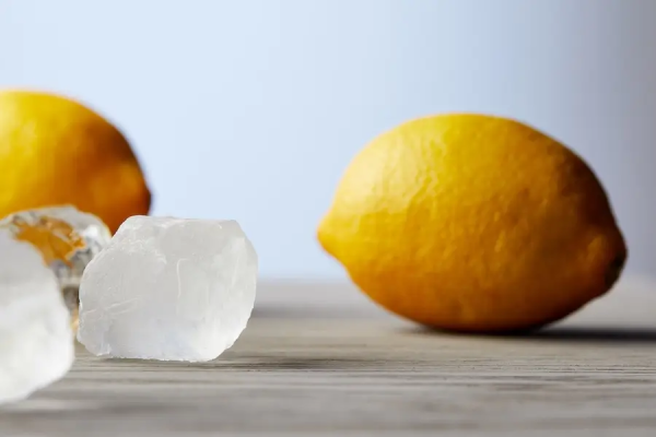 A close-up picture of ice cubes and lemons for cleaning a garburator.