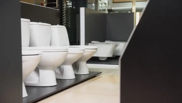 A range of elongated and round toilets available for sale in a store.