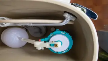 Interior view of various components inside a toilet tank.