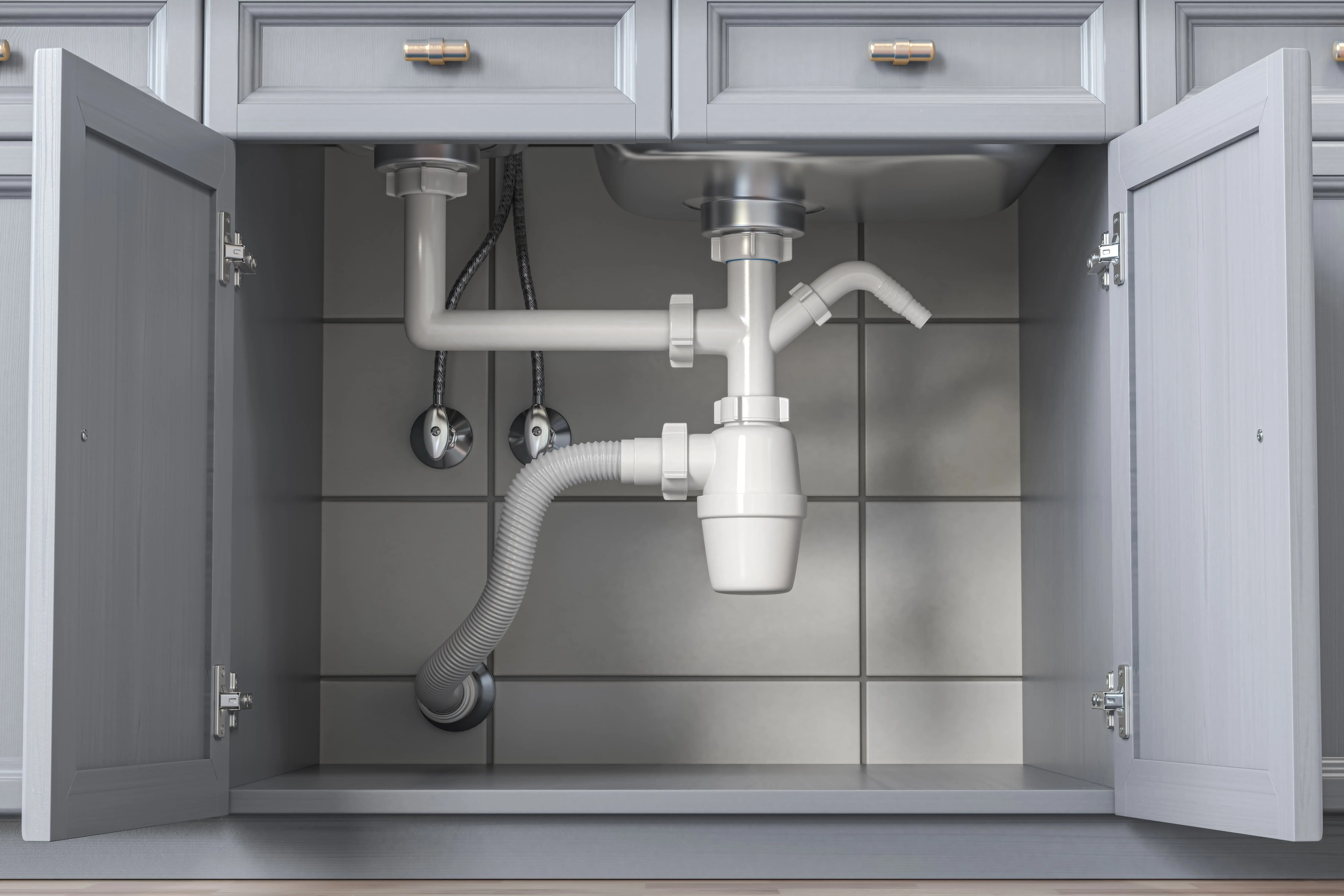 Under-sink plumbing showing a P-trap pipe, shutoff valves, and flexible water supply lines connected to a bathroom faucet. Pipes are clean and clearly arranged.