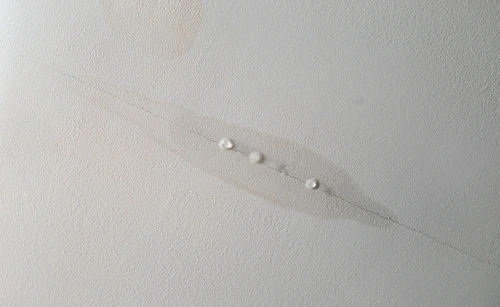 Water leaking from a drywall ceiling in a home.