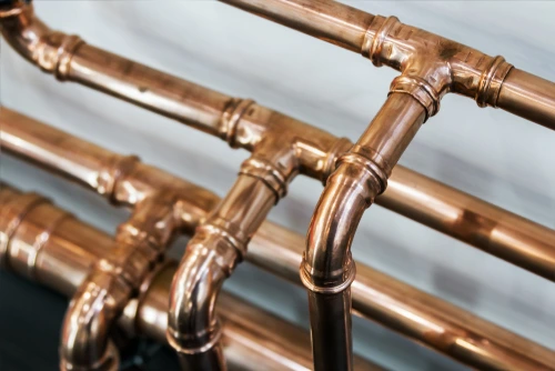A series of straight, curving, and joint copper water pipes