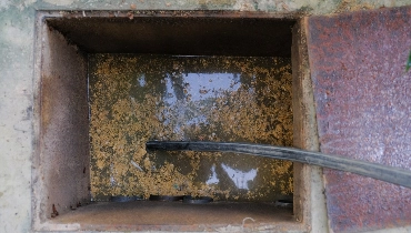 A hose being inserted into a sewer cleanout to remove the dirty wastewater that has filled the cleanout because of a sewer backup.