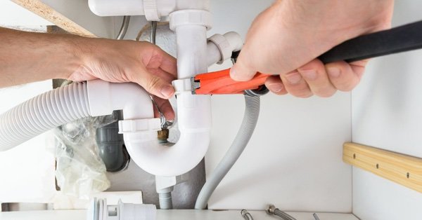 Mr. Rooter Plumbing technician using a wrench during drain repair in Mississauga, ON
