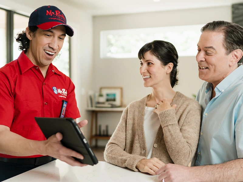 Mr. Rooter professional working with two customers.