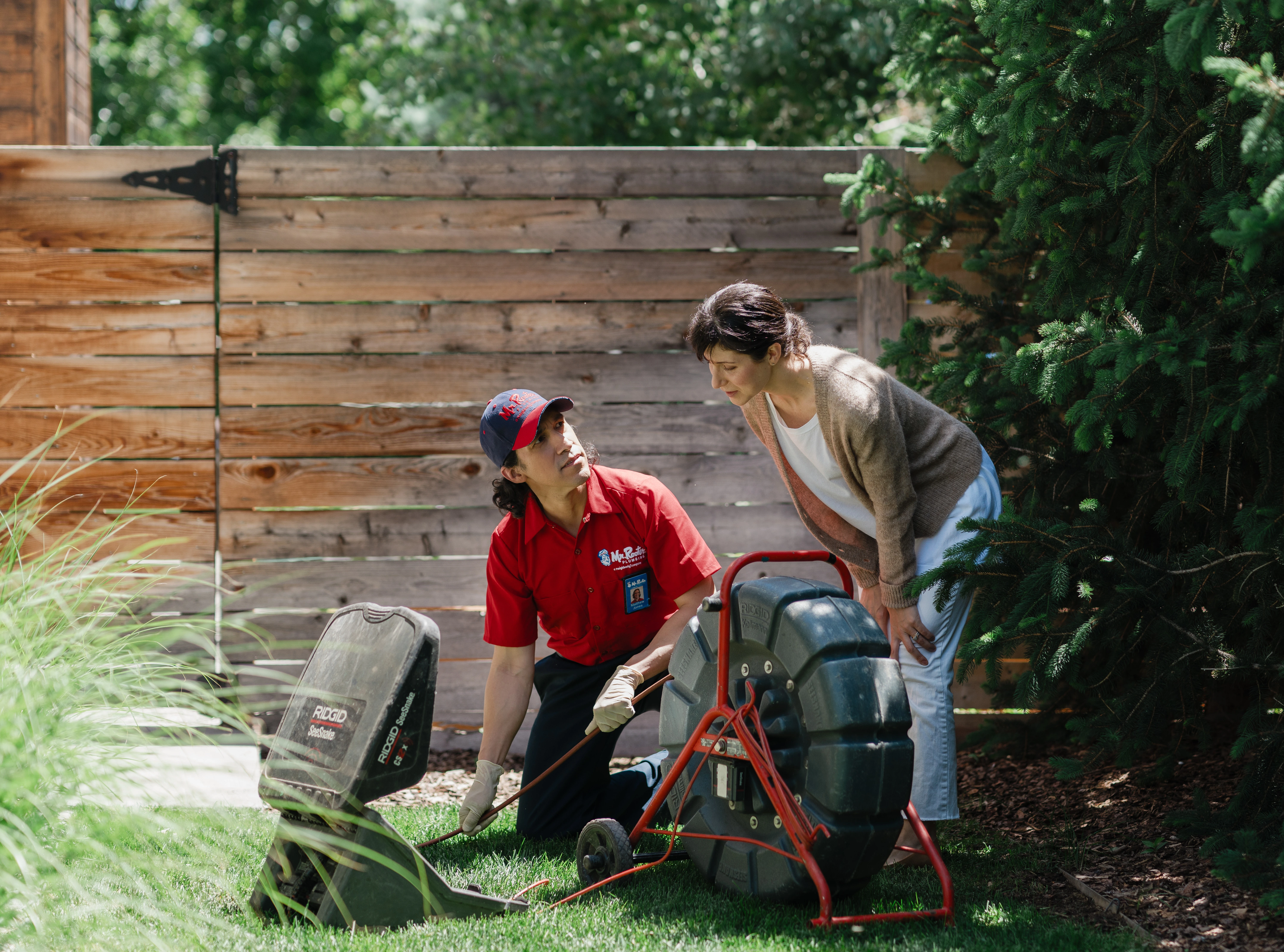 Plumber explaining a professional sewer cleaning process to a homeowner.