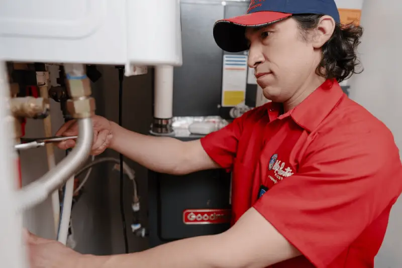 Licensed plumber servicing a residential water heater in Winnipeg.