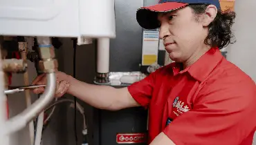 Licensed plumber servicing a residential water heater in Winnipeg.